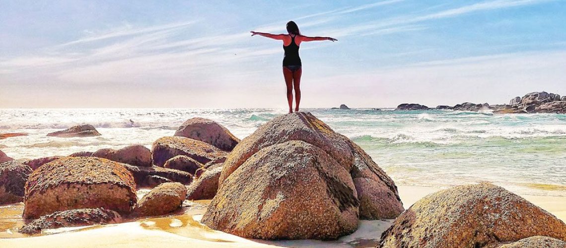 digital nomad standing on a rock staring into the ocean in cape town